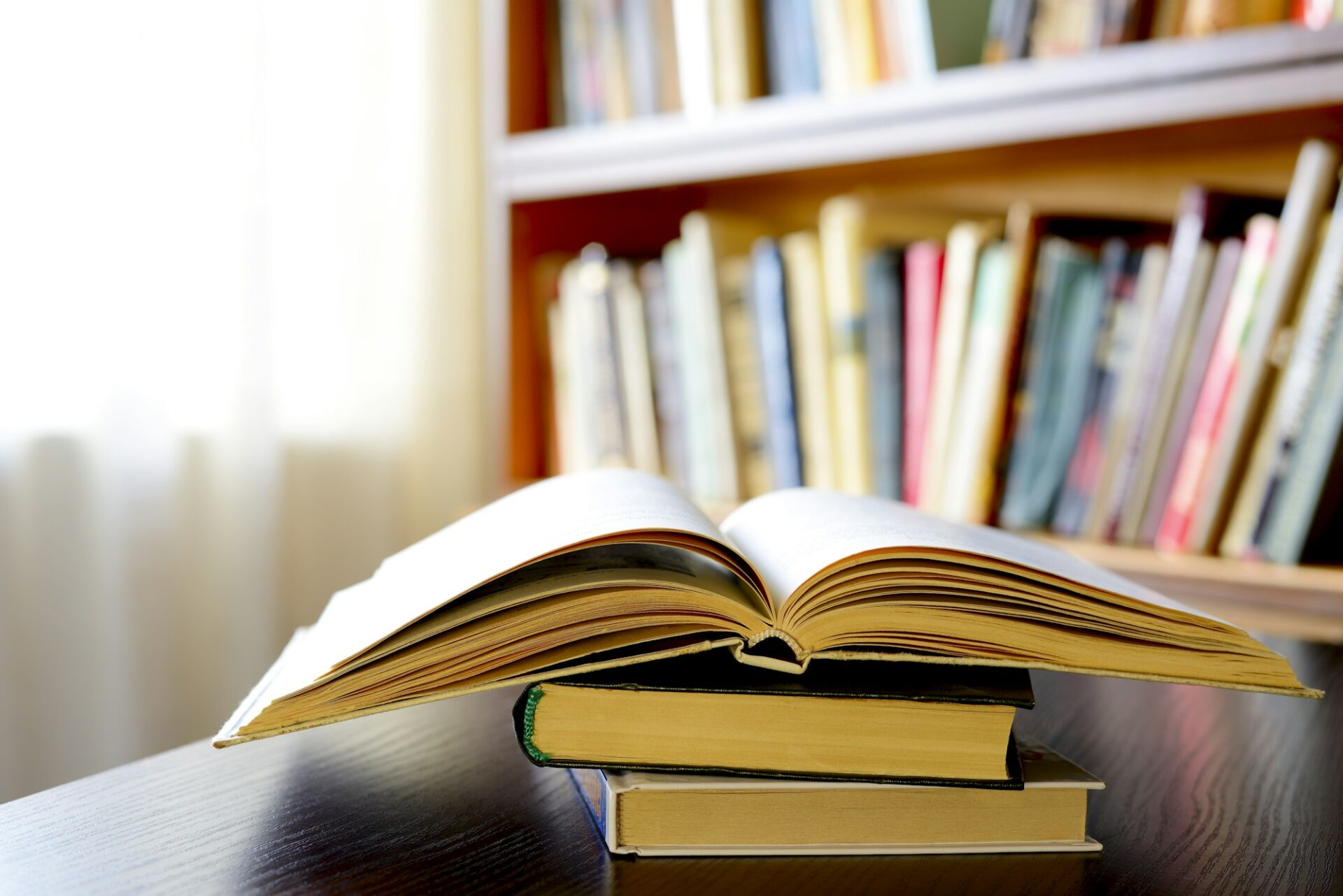 An open book with bookshelves in the background