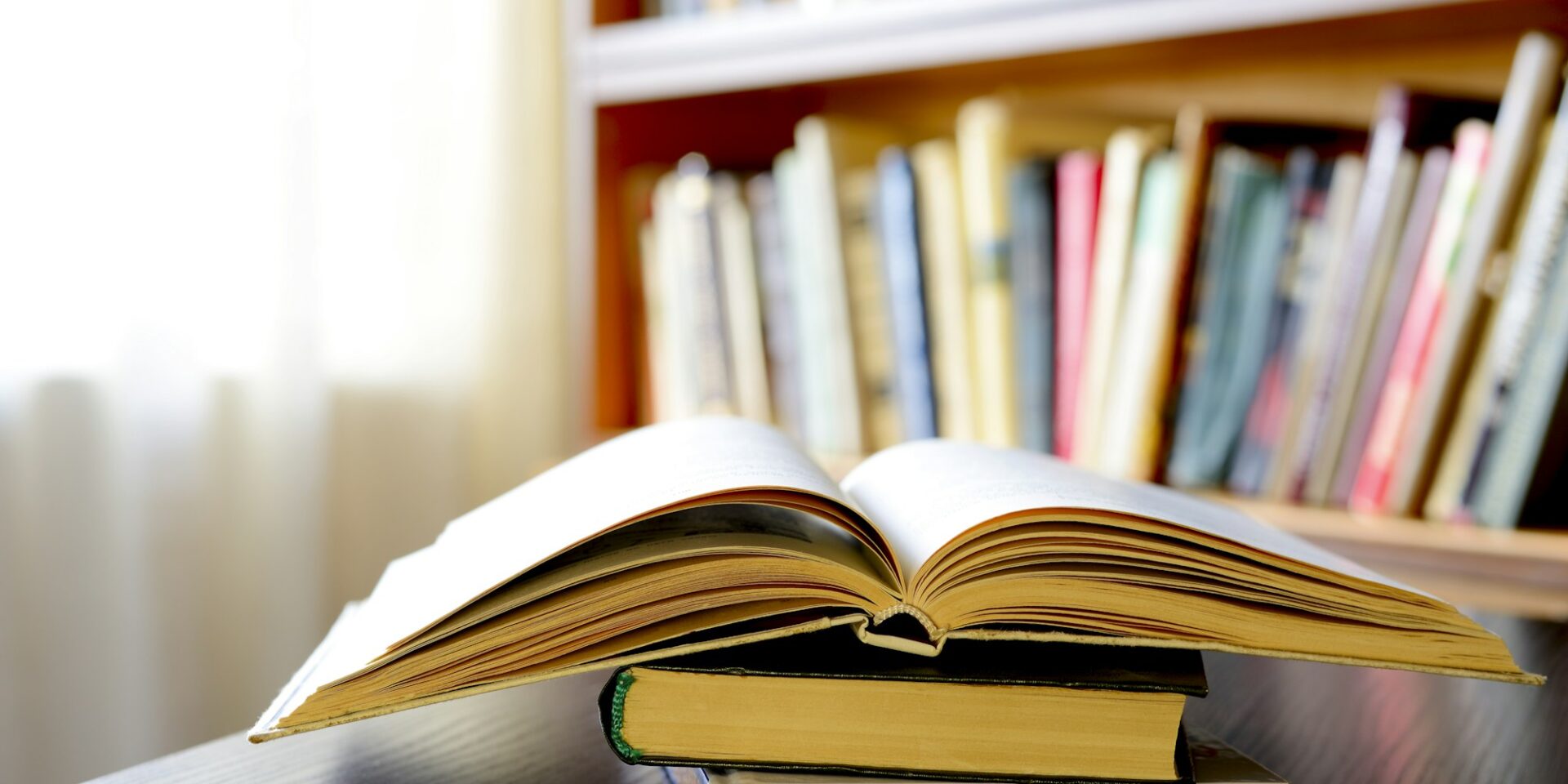 An open book with bookshelves in the background