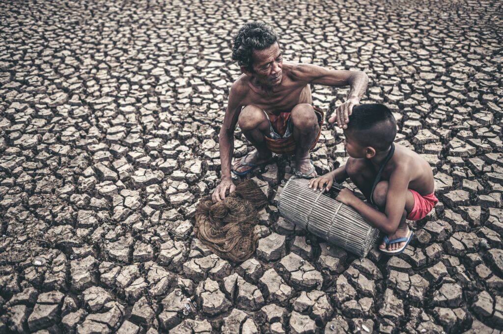 Elderly men and boy find fish on dry ground,global warming