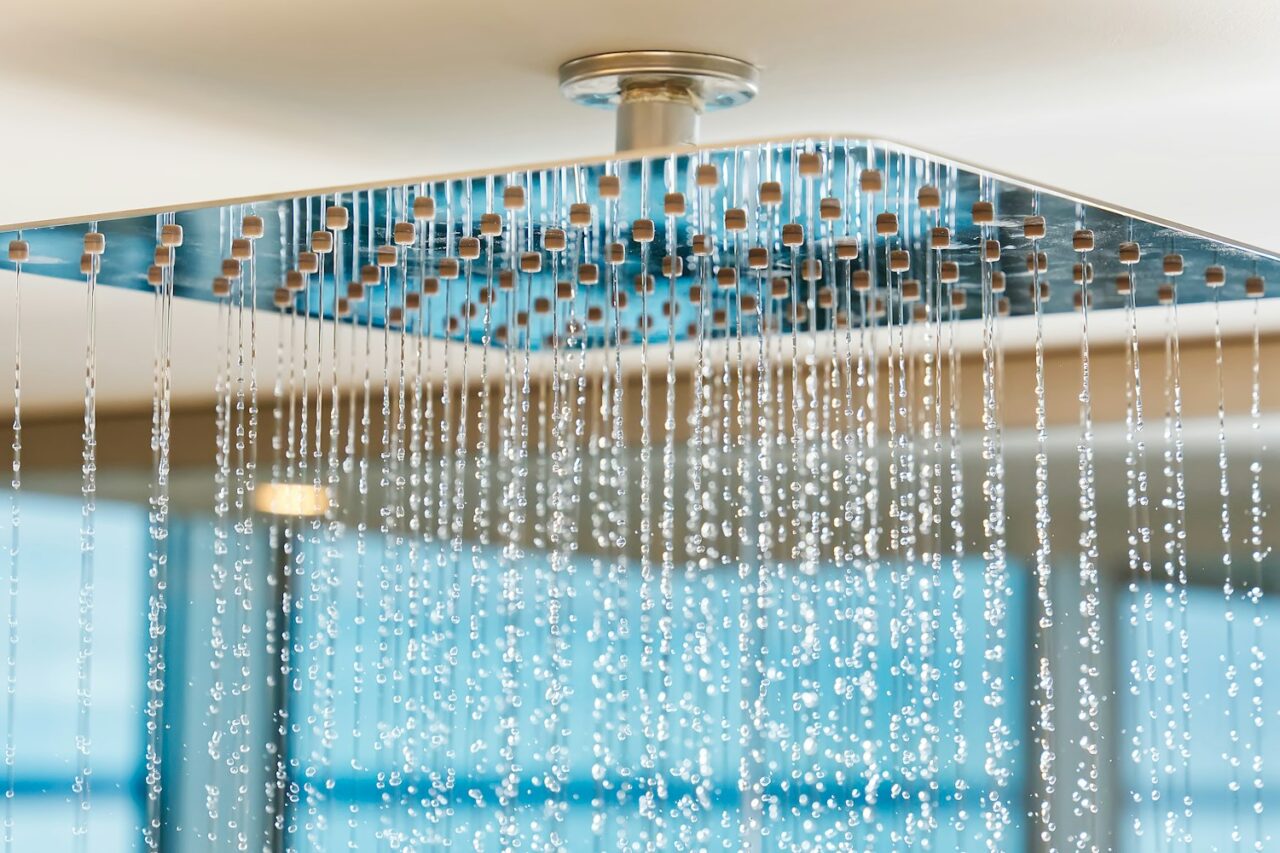 Water flows from the tropical shower. Large water consumption. Chrome shower head, modern design